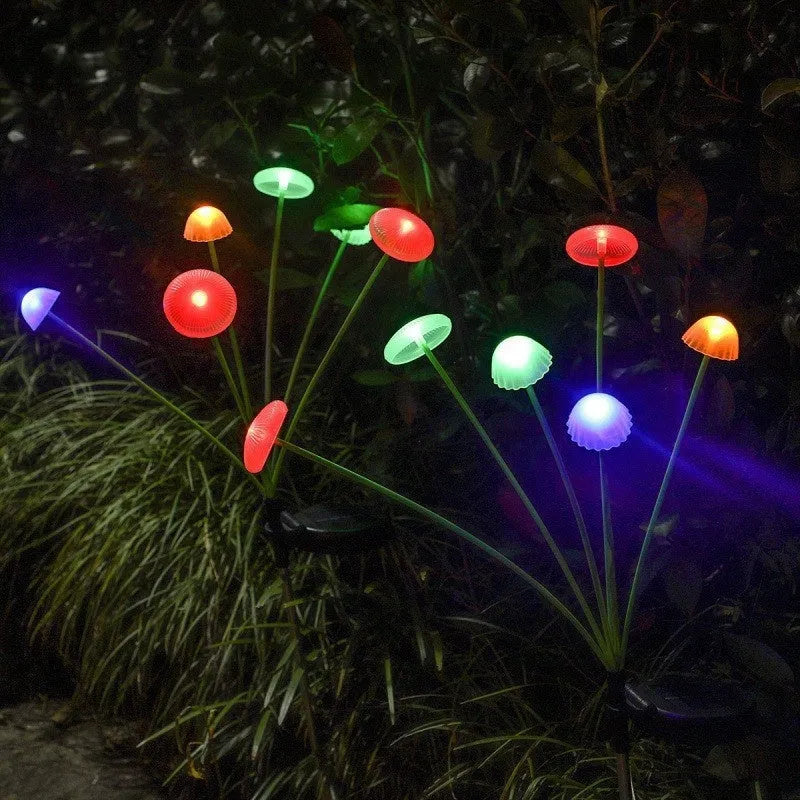 Solar jellyfish silicone garden lamp with warm LED lights on grass.