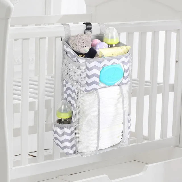 Grey attachable storage bag with diamond mesh panel and PP support plate, 44.6x23x16cm, hung on a white baby cot