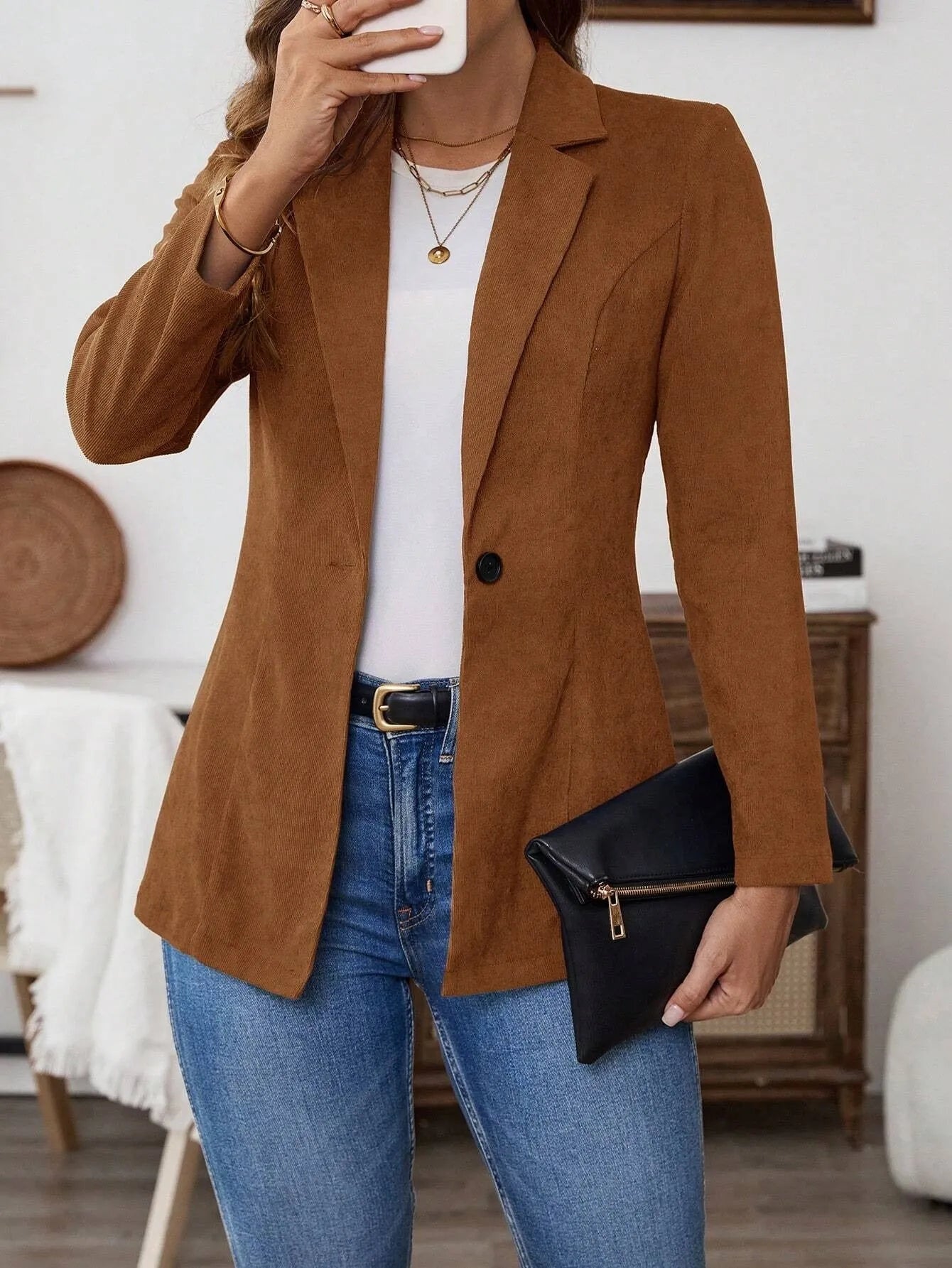 Brown men's single-breasted lapel coat with long sleeves on a hanger.