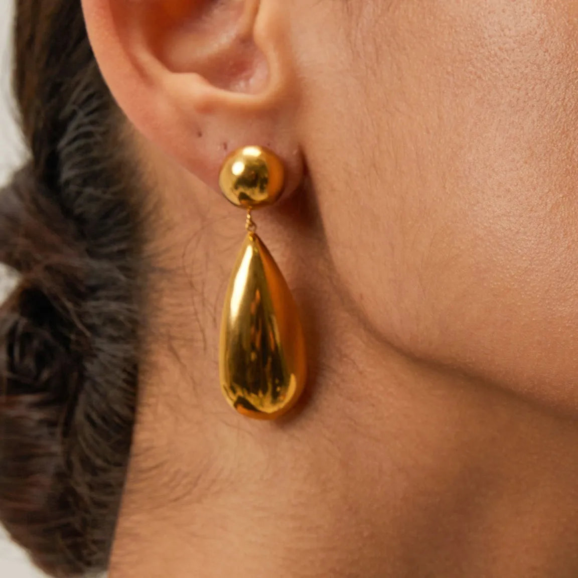 A pair of gold-coloured geometric water drop pendant earrings made from stainless steel.