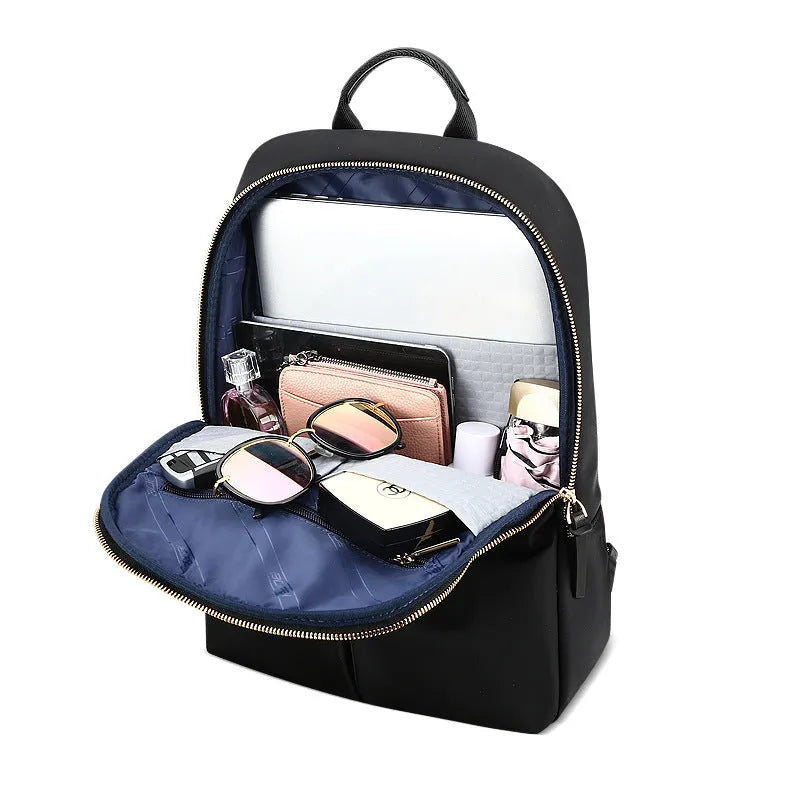 Women's black nylon backpack with zipper opening, internal computer sleeve, and phone pocket