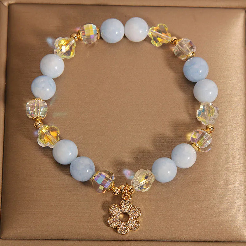 Women's aquamarine crystal bracelet with four-leaf clover design and a pearl accent.