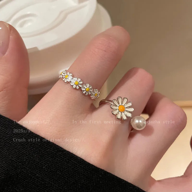 Women's copper opening ring with floral daisy charm and pearl accents on finger