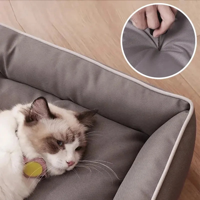 Grey waterproof dog sofa bed with cushioned sides on a wooden floor.