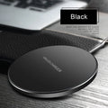 Black ultra-thin square wireless charging pad with USB cable on a desk.