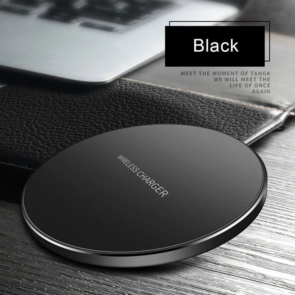 Black ultra-thin square wireless charging pad with USB cable on a desk.