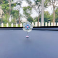 Small blue plastic swing ornament for car dashboard, 5cm tall on a grey surface.