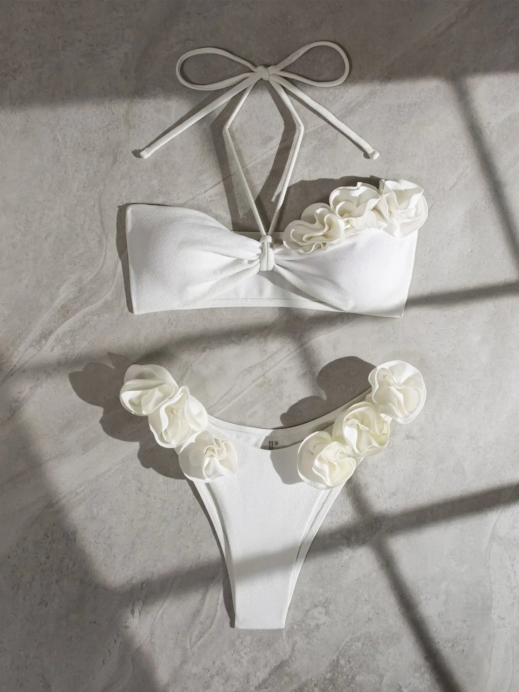 White women's swimsuit with 3D floral pattern, halter neck, and lace-up back.