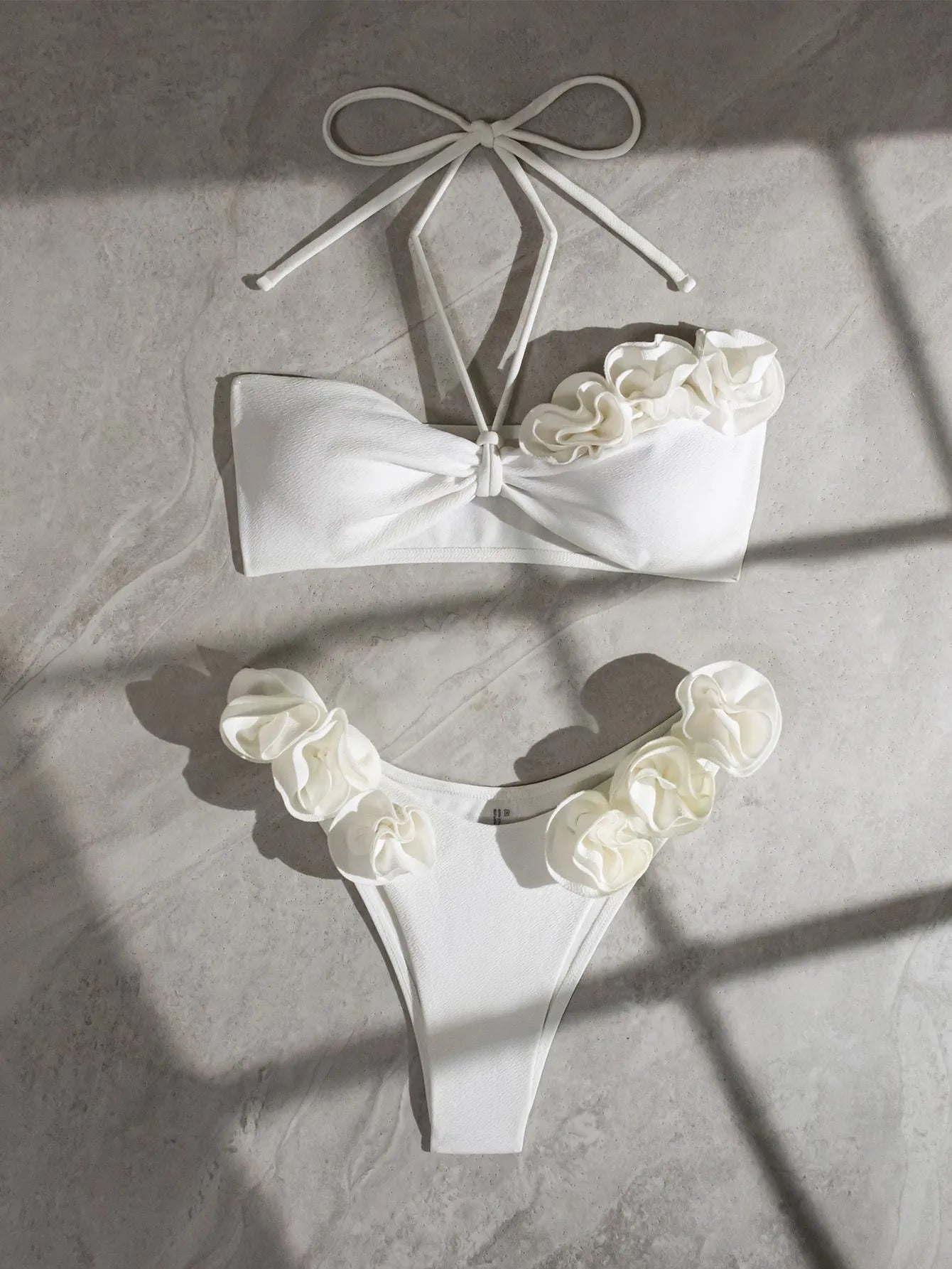 White women's swimsuit with 3D floral pattern, halter neck, and lace-up back.