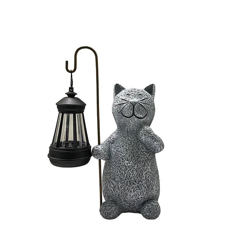 Solar-powered garden light with decorative resin kitten ornament lifting a lamp.