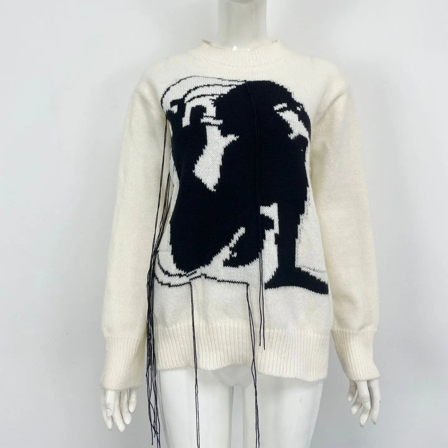 Grey loose women's alpaca wool pullover sweater with tassel detail on a hanger.