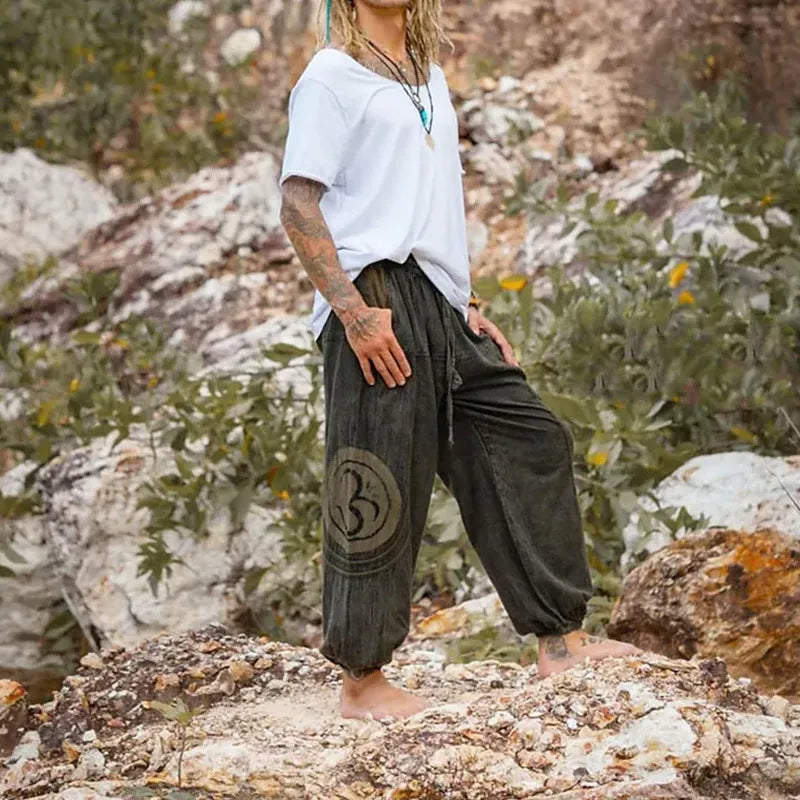 Men's dark green ethnic pattern casual ankle-tied trousers on model, polyester fabric