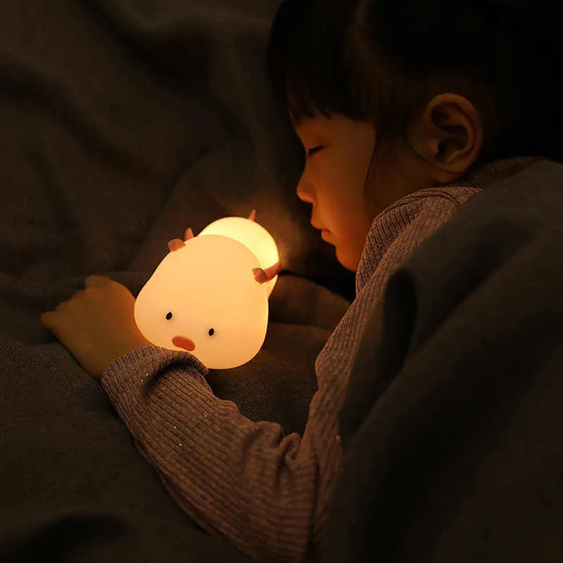 Blue rechargeable silicone night light shaped like a sleeping pig with soft LED glow.