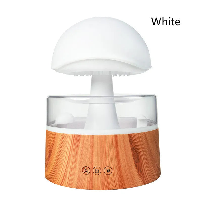 White plastic rain cloud humidifier with mist and coloured night light on a wooden surface