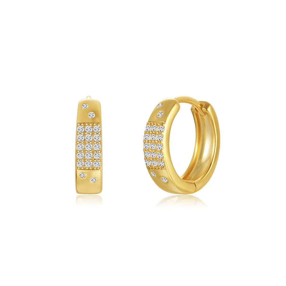 A pair of geometric brass earclip earrings with round diamond details on a gold electroplated copper base.