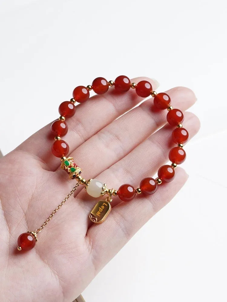 Gold-plated women's bracelet with red agate and Hetian jade beads in a traditional pattern.