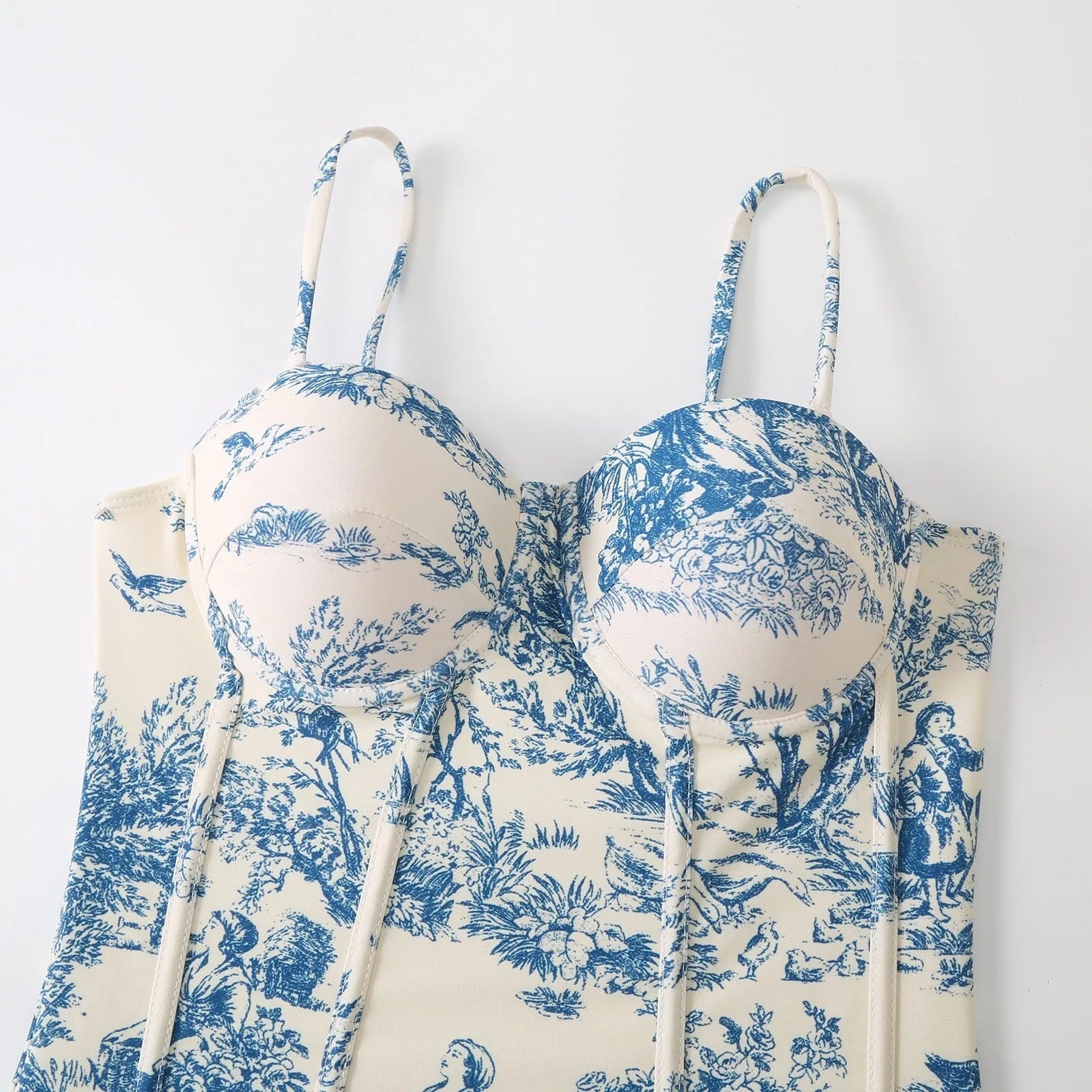 Blue women's one-piece polyester swimsuit with a matching gauze skirt laid flat.