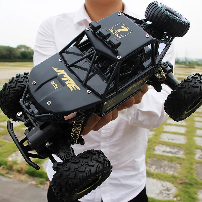 Large black 4WD remote control off-road climbing car on rough ground