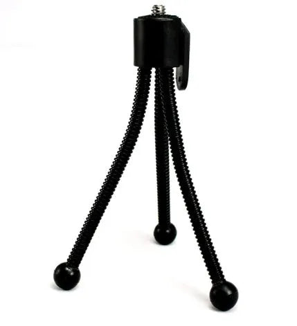 Small black iron frame mini tripod with folded legs and a ball head, shown next to a smartphone.