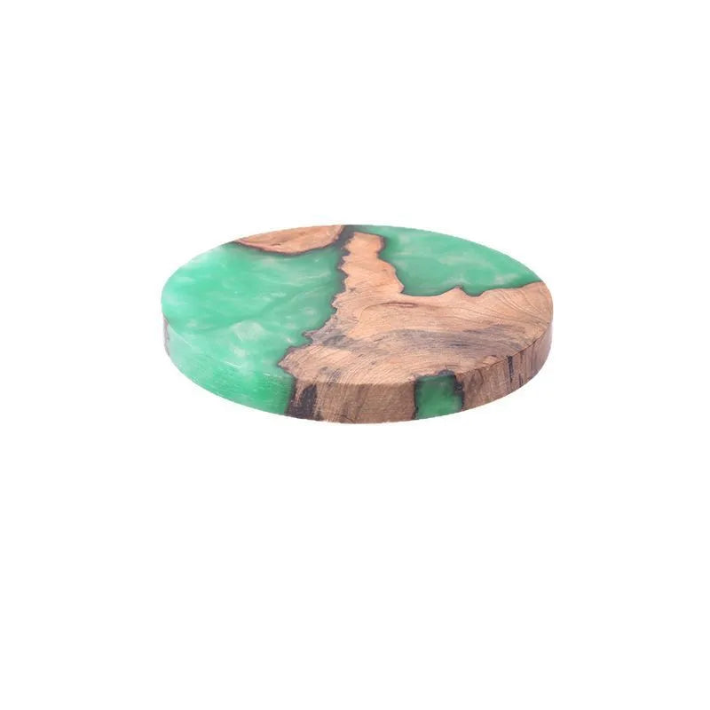 A solid colour resin coaster on a wooden table, showing its 1cm thickness and irregular Nordic shape.