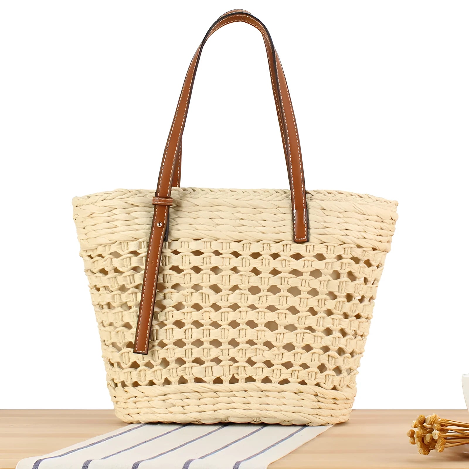 Paper woven shoulder bag with adjustable strap in beige colour showing horizontal square shape and straw decorative elements