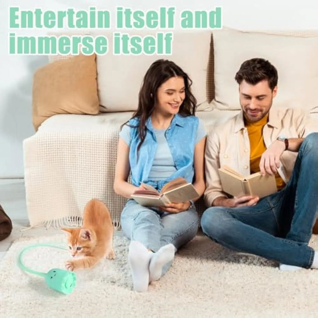 Green automatic cat wand toy with swinging silicone tails on a wooden floor.