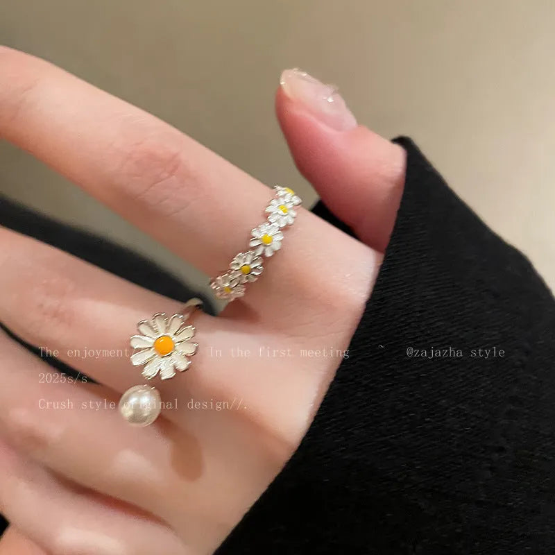 Women's copper opening ring with floral daisy charm and pearl accents on finger