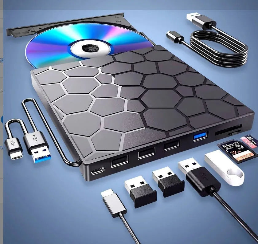 Black portable external USB CD/DVD drive and writer on a desk next to a laptop