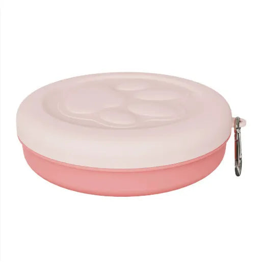Collapsible two-layer silicone dog travel bowl in light pink and green, showing food and water compartments.