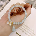 Chinese style women's jade bracelet with traditional gourd design featuring emerald jade insets and pearl elements