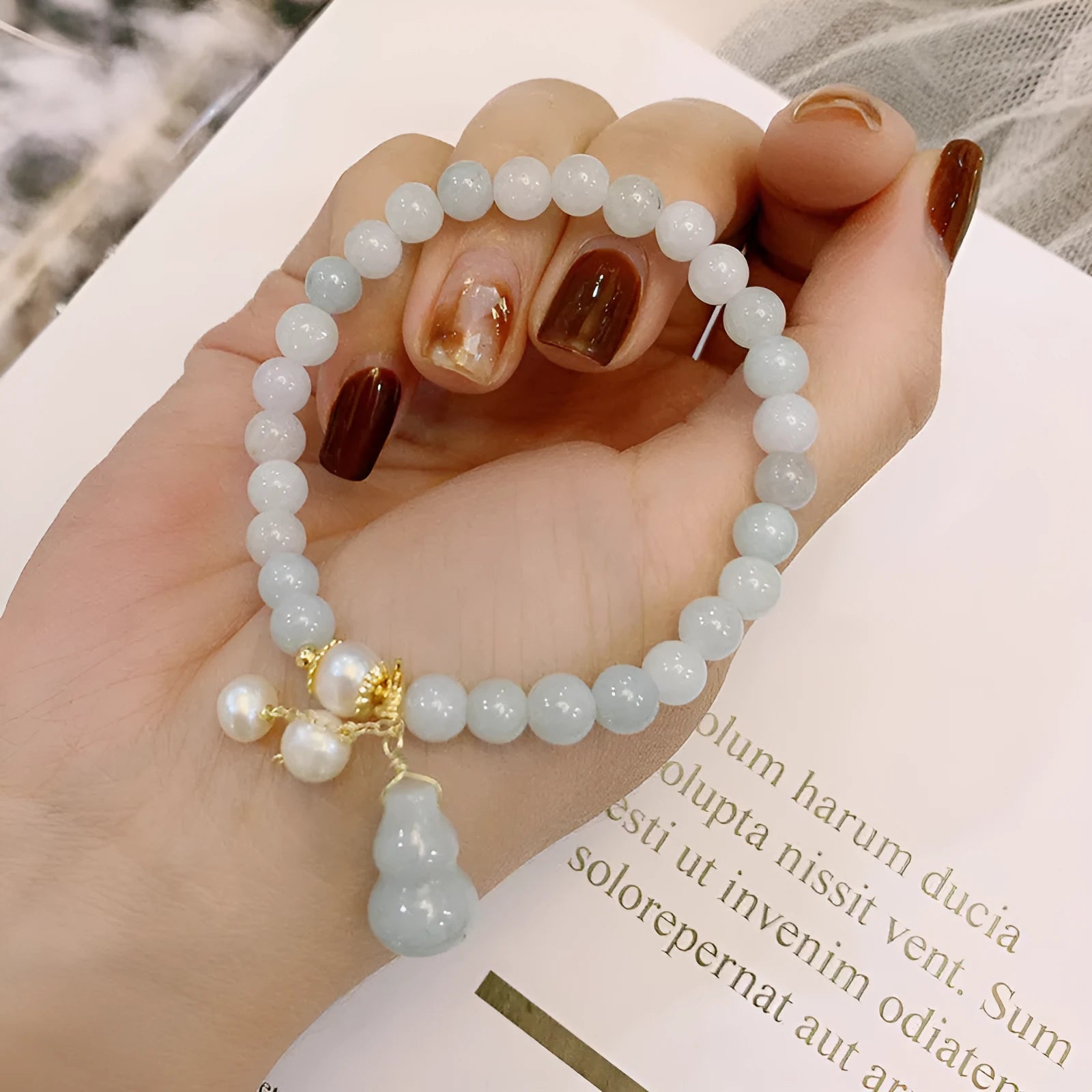 Chinese style women's jade bracelet with traditional gourd design featuring emerald jade insets and pearl elements