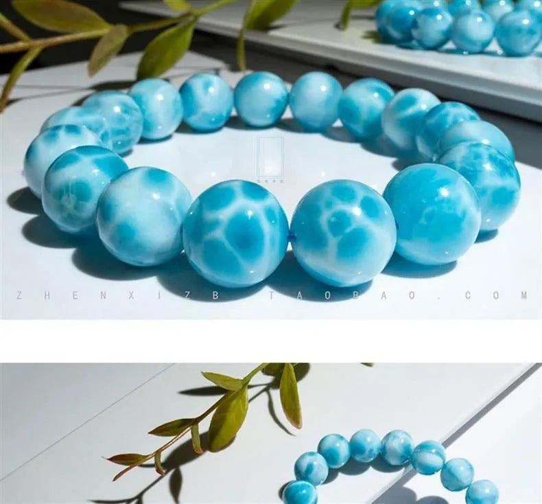 Blue handmade Bodhi bead bracelet with natural crystal and sea-pattern stone on a wrist.