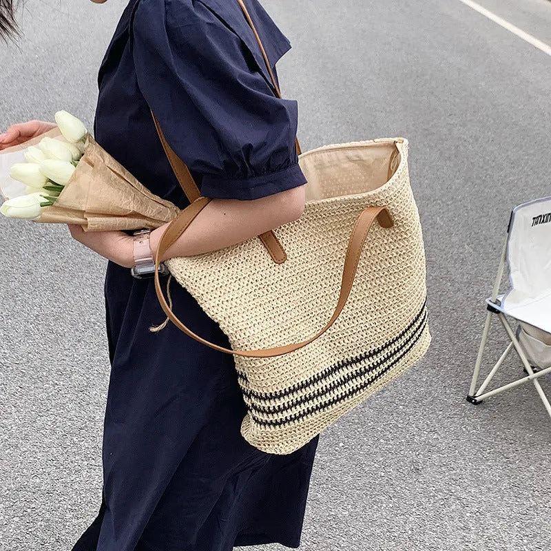 Large striped straw woven handbag with 64cm shoulder strap and polyester lining, shown in khaki or black
