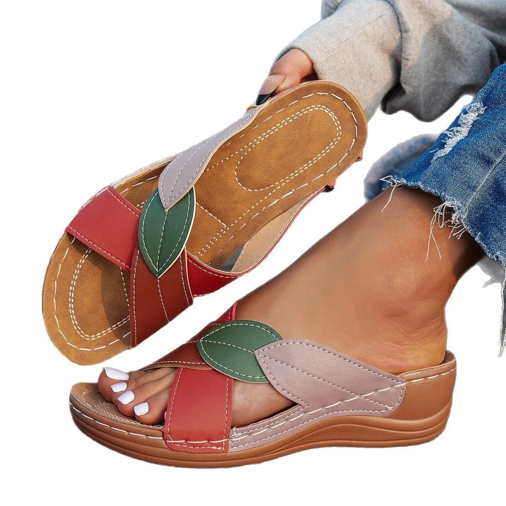 Women's black thick-soled slippers with a cross-strap and peep-toe fish-mouth design on a white background.