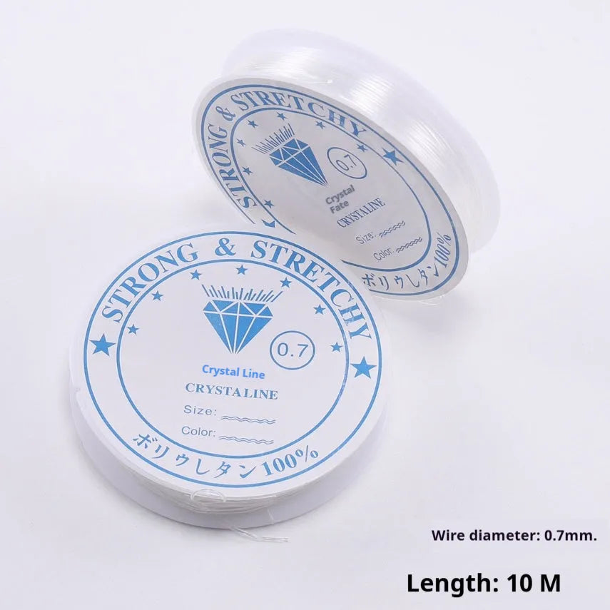 Spool of transparent crystal clear elastic cord for DIY jewellery making and beading projects on a wooden surface.