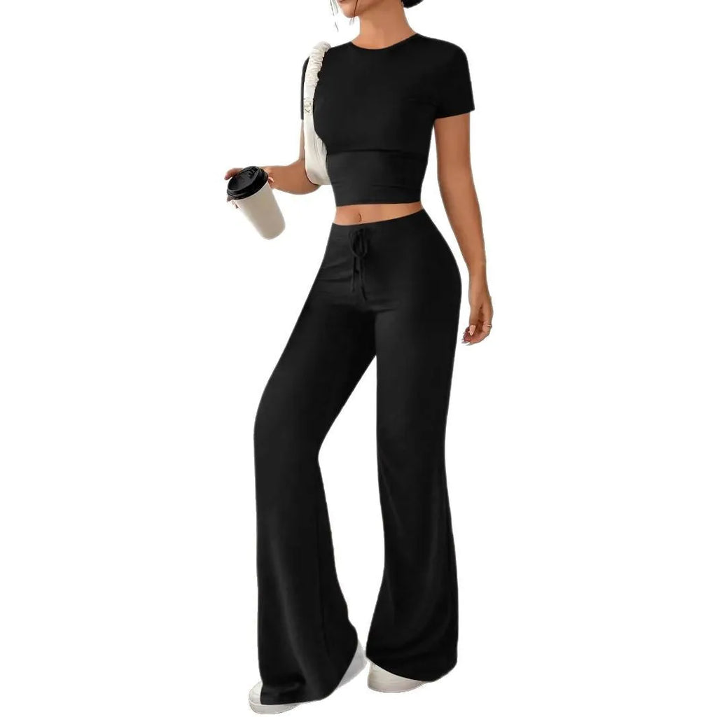 Black women's high waist trousers and short sleeve T-shirt lounge suit set on a plain background.