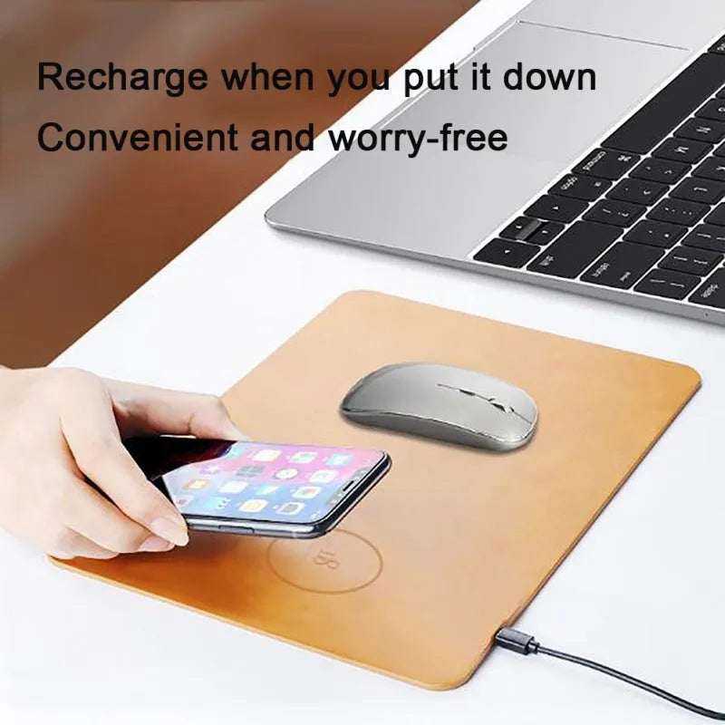 Brown leather-texture wireless charging mouse pad with a phone placed on it charging, on a wooden desk.