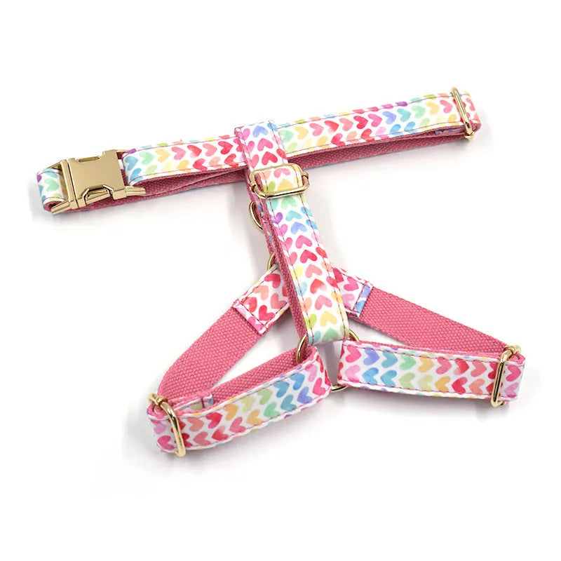 Pink colourful dog chest and back harness with gold buckle and heart-shaped stone details.