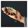 Rosewood bracelet with carved Fu character and amass fortunes design showing 12 wooden beads