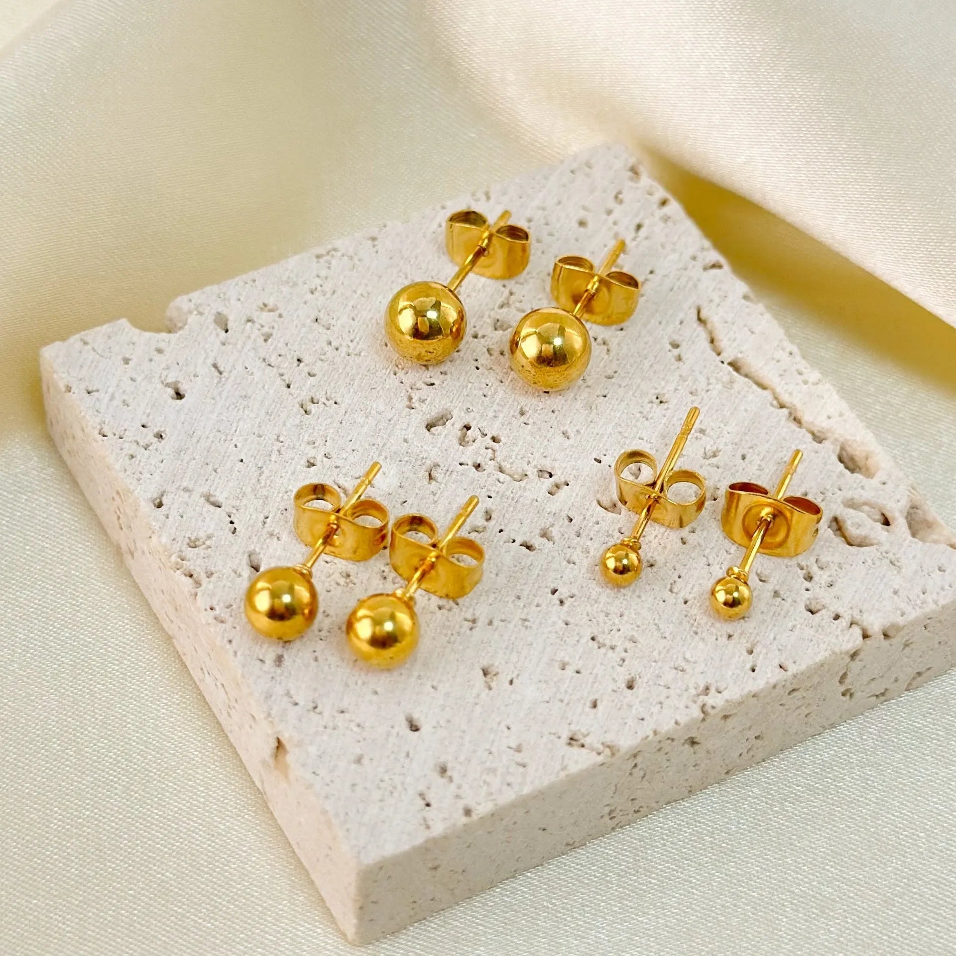 Minimalist stainless steel ball stud earrings in gold or silver, showing 3mm, 4mm, 5mm, and 6mm size options.