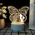 White heart-shaped acrylic table lamp with glowing warm light on a wooden surface.