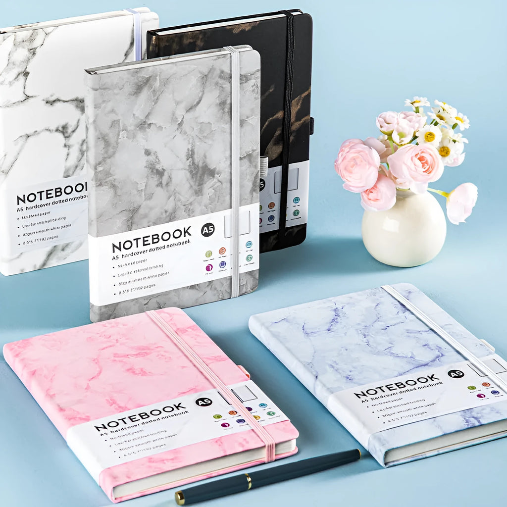 A5 size notebook with soft skin-feel PU leather cover and strap closure, open to show horizontal lined pages.