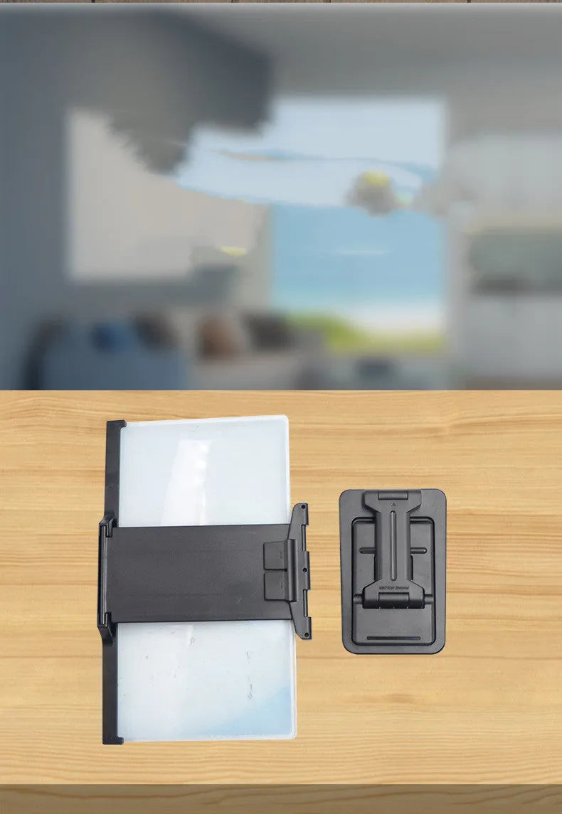 Black folding mobile phone screen magnifier with detachable holder next to an iPhone.