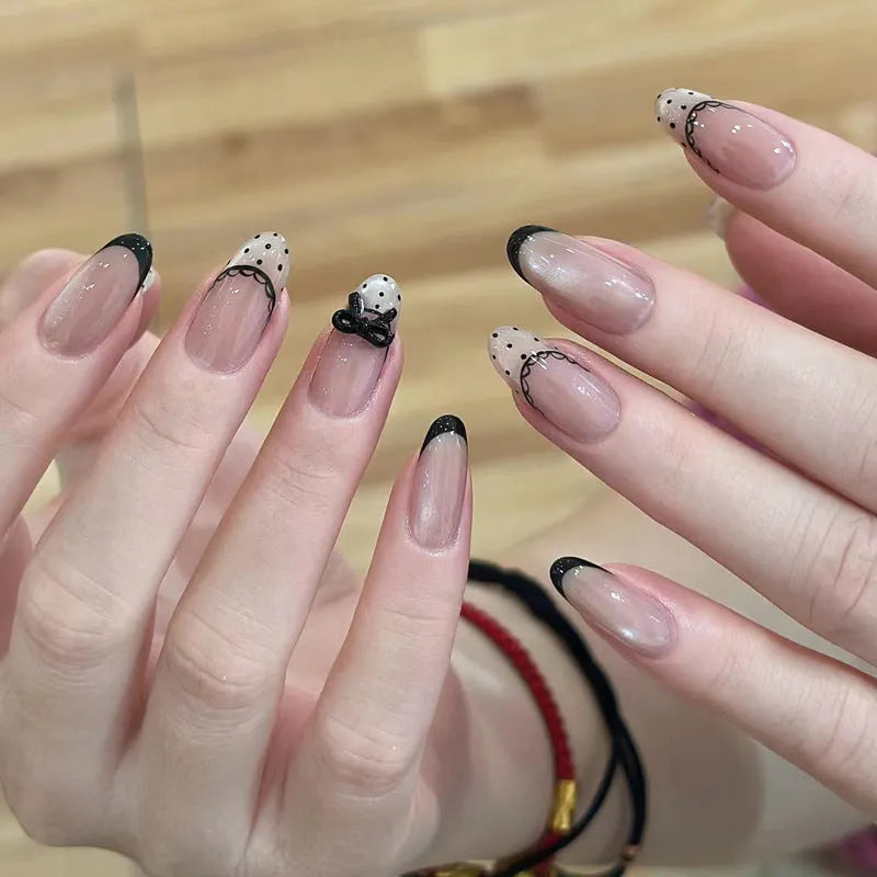 Assortment of sweet girl style false nails in various colours and designs, laid out on a table.
