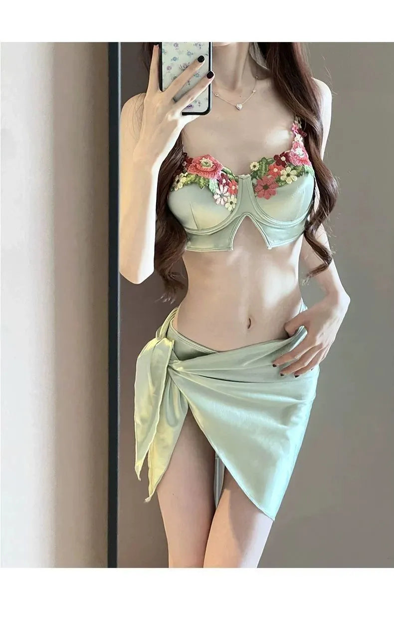 Green women's bikini three-piece set with triangle top, briefs, and skirt cover-up