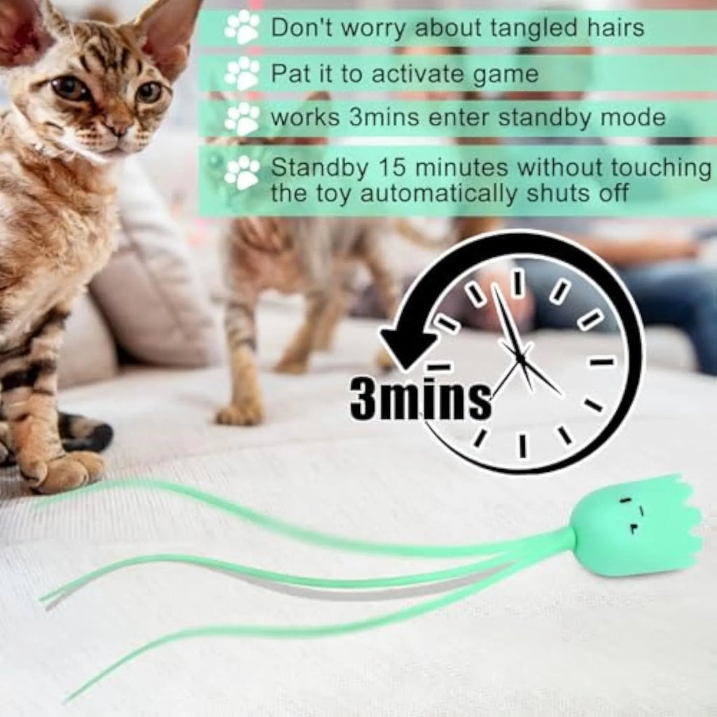 Green automatic cat wand toy with swinging silicone tails on a wooden floor.