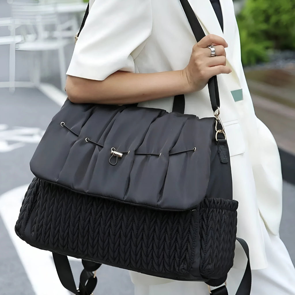 Black polyester one-shoulder insulated waterproof bag with curved strap and woven detailing