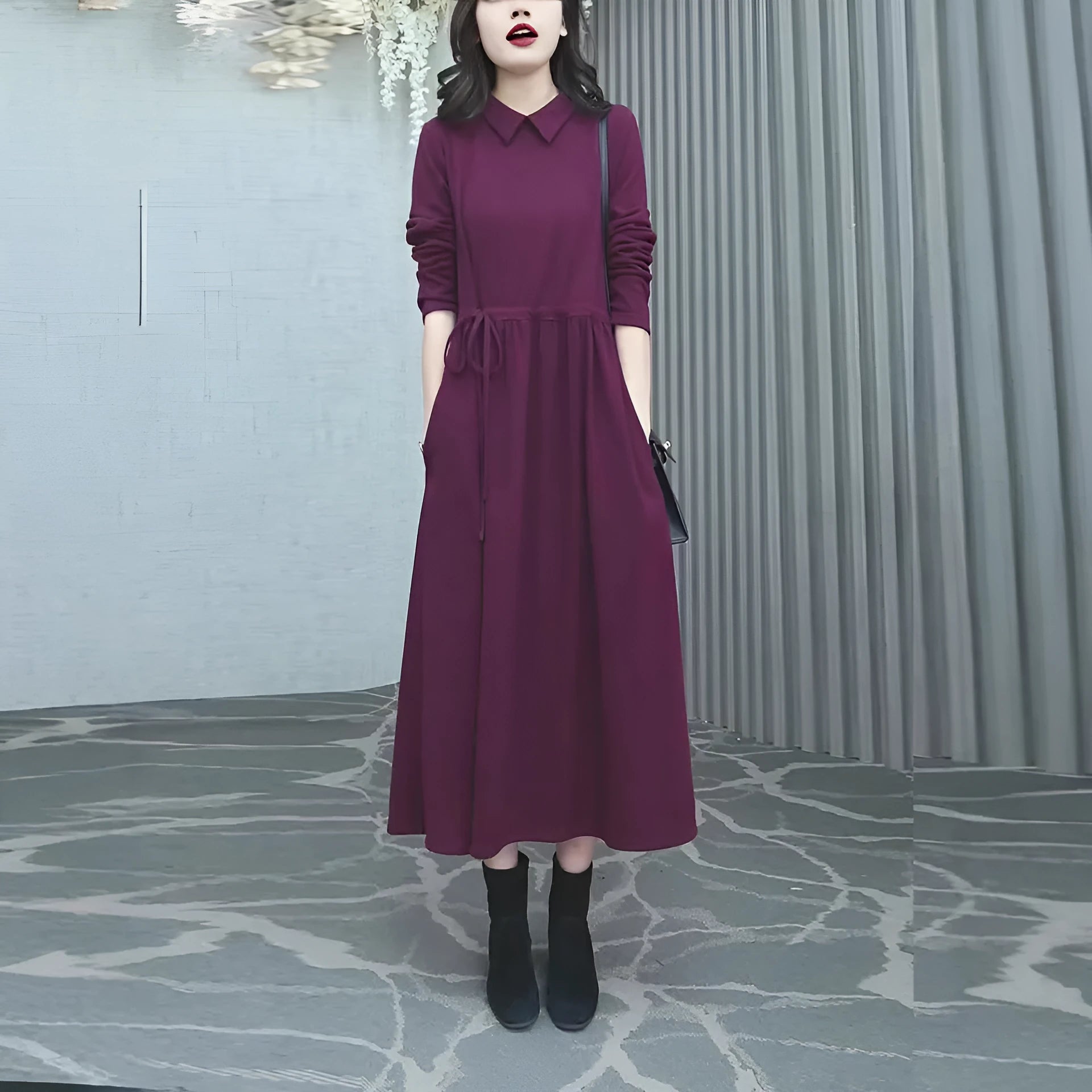 Purplish red plus size long sleeve winter dress for women on a hanger.