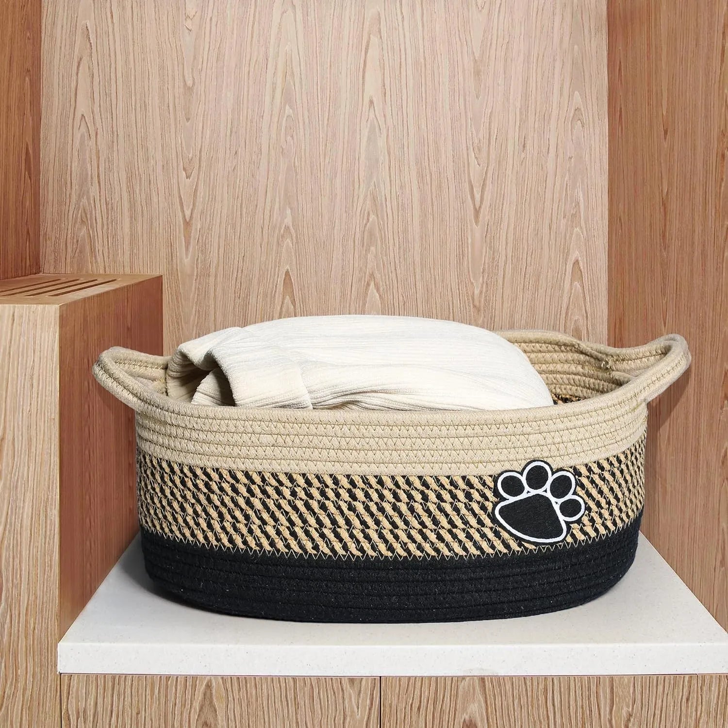 Small light beige woven cotton rope storage basket with wooden handles for organisation