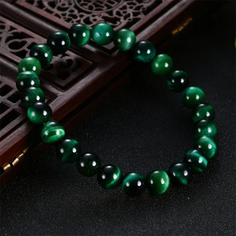 Green Tiger Eye stone bracelet with round polished beads on a wrist.